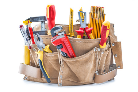 construction hand tools in brown leather tool belt isolated on white
