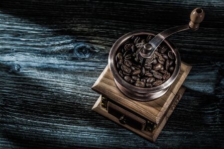 Coffee mill beans on wooden board.の写真素材