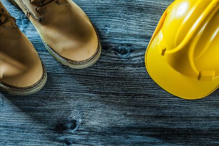 Safety boots hard hat on vintage wooden board.の写真素材