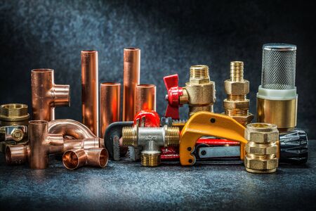 pipe cutter and adjustable wrench with brass copper connectors big set on dark backgroundの写真素材