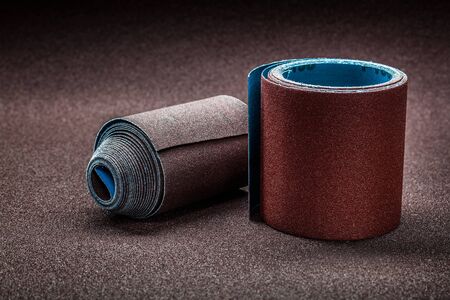 big rolls of abrasive paper on background of biggest sheet of sandpaperの写真素材