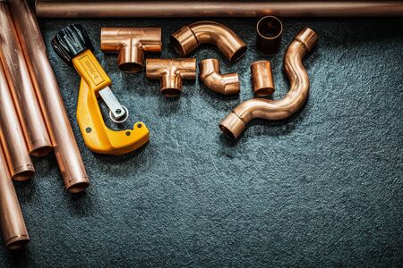 plumbing concept copper pipes pipe cutter and fittings on black backgroundの写真素材