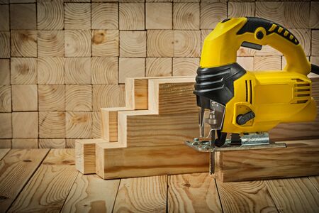 construction tools  in real conditions yellow corded jigsaw stay on wooden beamの写真素材