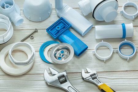 white plastic plumbing accsessories on wooden backgroundの写真素材