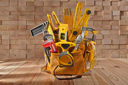Big Set Of Carpenter Working Tools In Leather Toolbelt On Background of Wooden Beams Stackの写真素材