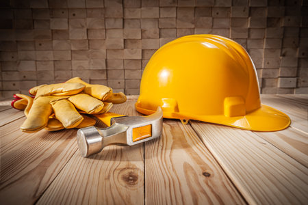 Construction Safety Tools And Workwear. Yellow Helmet Claw Hammer Leather Gloves. Wooden Beams Stackの写真素材