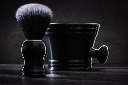 black shaving brush with bowl on dark background close up viewの写真素材