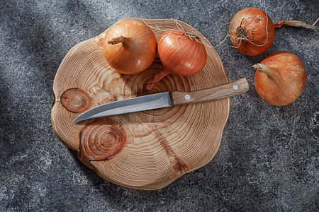 Wooden Cutting Board With Onion And Kitchen Knifeの写真素材