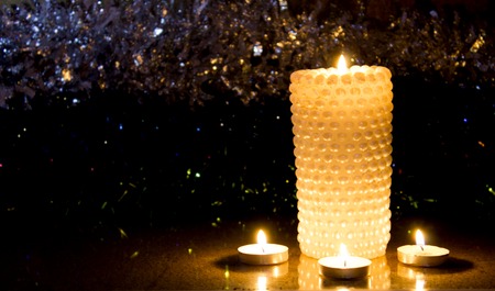 Four Christmas candles at night on the tinsel, as babackgroundの写真素材