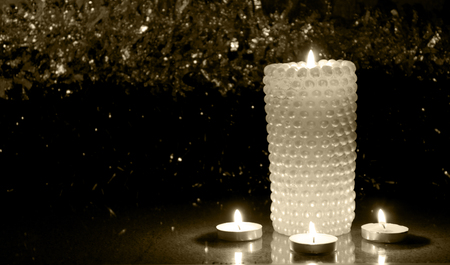 Four Christmas candles at night on the tinsel, as babackgroundの写真素材