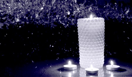 Four Christmas candles at night on the tinsel, as babackgroundの写真素材