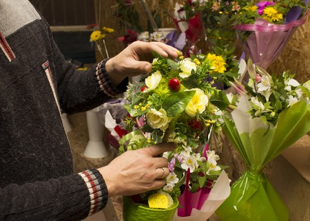 Man creates a bouquet with ping ribbonの写真素材