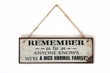 Board on a wall - Remember we are a normal family - Sarcastic funny thought on banner - inspiration hanging signの写真素材