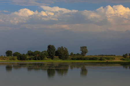 Beautiful summer landscape with river and clouds in the blue sky.