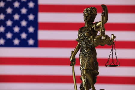 Statue of justice with American flag in the background, legal concept