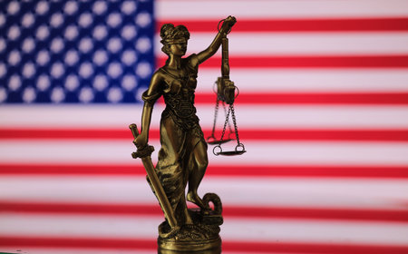 Statue of justice on the background of the American flag. The concept of law and justice.