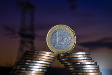 Coins stacked on each other in the background of the oil derrick