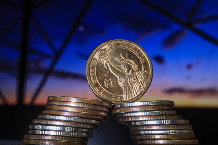 Coins stack on blurred background of sunset sky. Business concept.