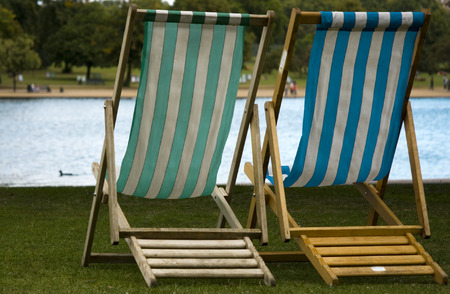 Two benches left empty in front of a pondの写真素材