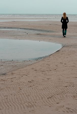 A lonely girl standing at the seashoreの写真素材