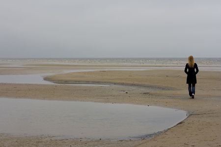 A lonely girl standing at the seashoreの写真素材