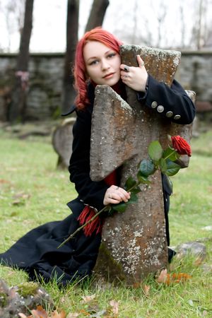 Gothic girl with a rose on a cemeteryの写真素材