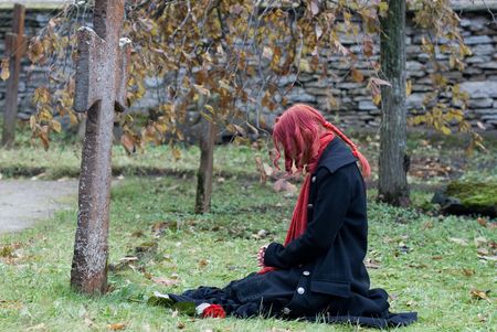 Gothic girl with a rose on a cemeteryの写真素材