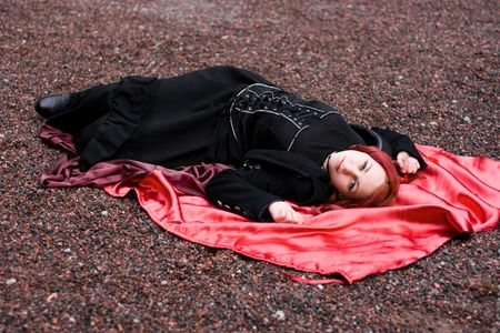 Redhead girl in with red satin cloakの写真素材