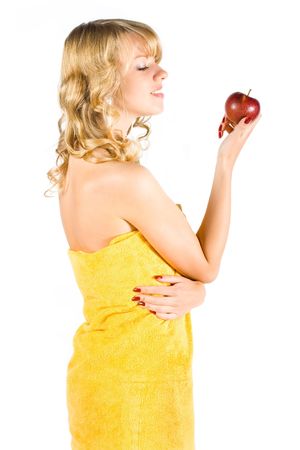 Young sexy girl in towel in going to bite an appleの写真素材