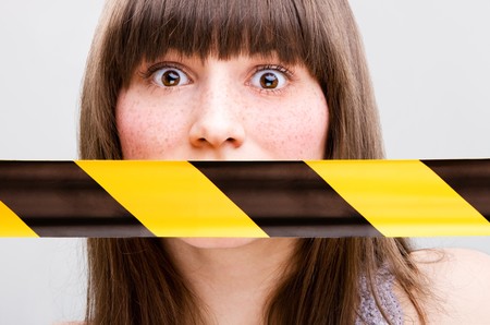 Portrait of young woman with taped mouthの写真素材