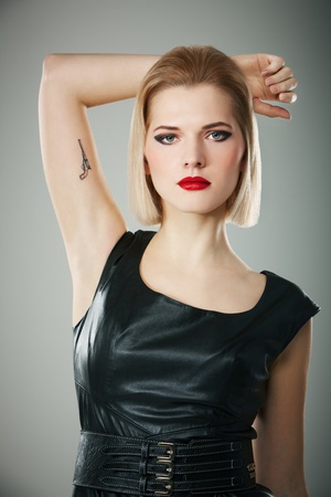 Portrait of young woman with gun tattoo on her armの写真素材