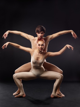 Couple of ballet dancers posing over dark backgroundの写真素材