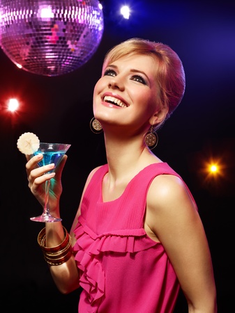 Happy beautiful girl with a drink in nightclubの写真素材
