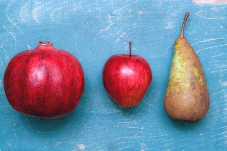 garnet, apple, pear on blue wooden backroundの写真素材