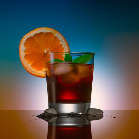 alcohol coctail drink with ice cubs on a color backgroundの写真素材