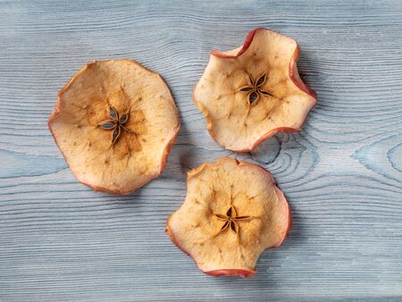Top view of tree apple chips on a white wooden backgroundの写真素材
