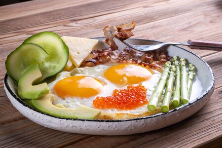 Close up view of the ketogenic diet breakfast on the white plate with a fork on rustic backgroundの写真素材