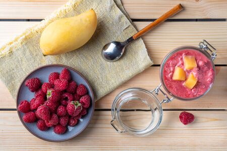 Top view of the cup of raspberries smoothie with mango on white wooden background.の写真素材
