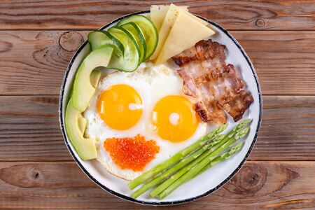 Top view of ketogenic diet breakfast on the white plate on wooden background.の写真素材