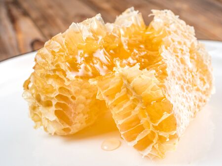 Top view of the wooden spoon of bee pollen with honeycombs on wooden background. Selective focusの写真素材