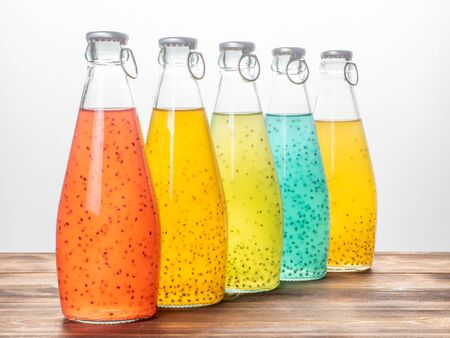 Five bottles of Basil Seed in line on a white background. Red, yellow, light blue and green color. Selective focusの写真素材