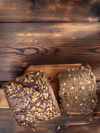 Top Vertical View of Brown Homemade Bread on wooden background illuminated by sunlight. With copy space.の写真素材