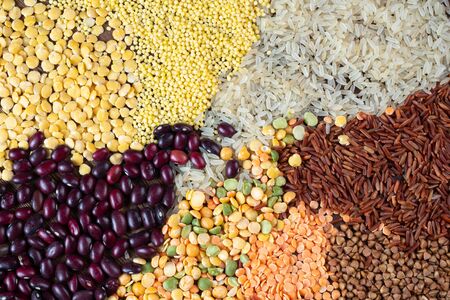 Close up view of different types of grains and cereals on a wooden background.の写真素材