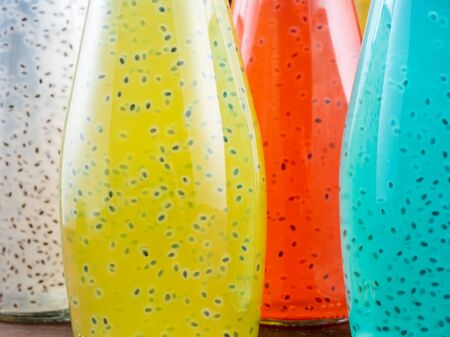 Close up view of bottles of Basil Seed beverage. Red, light blue and green color. Selective focusの写真素材