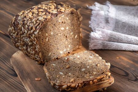 Close up View of Brown Homemade Bread on wooden background illuminated by sunlight. Selective focus.の写真素材
