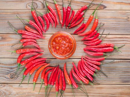 Hot chili pepper lay around of glass jar of harissaの写真素材