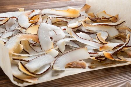 Close up view of dried coconut chips in on baking paperの写真素材
