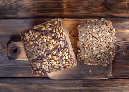 Top View of Brown Homemade Bread on wooden background illuminated by sunlightの写真素材