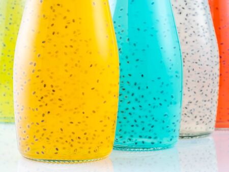 Close up view of bottles of Basil Seed beverage. Red, yellow, light blue and green color. Selective focusの写真素材