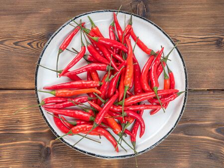 The plate of hot chili pepper on wooden backgroundの写真素材